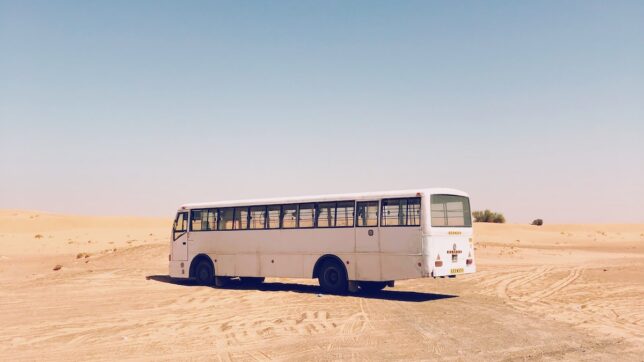 white bus on desert during daytime